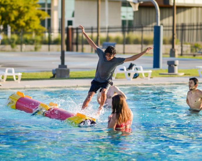 Four people having fun at the pool at the Morris Recreation Center.