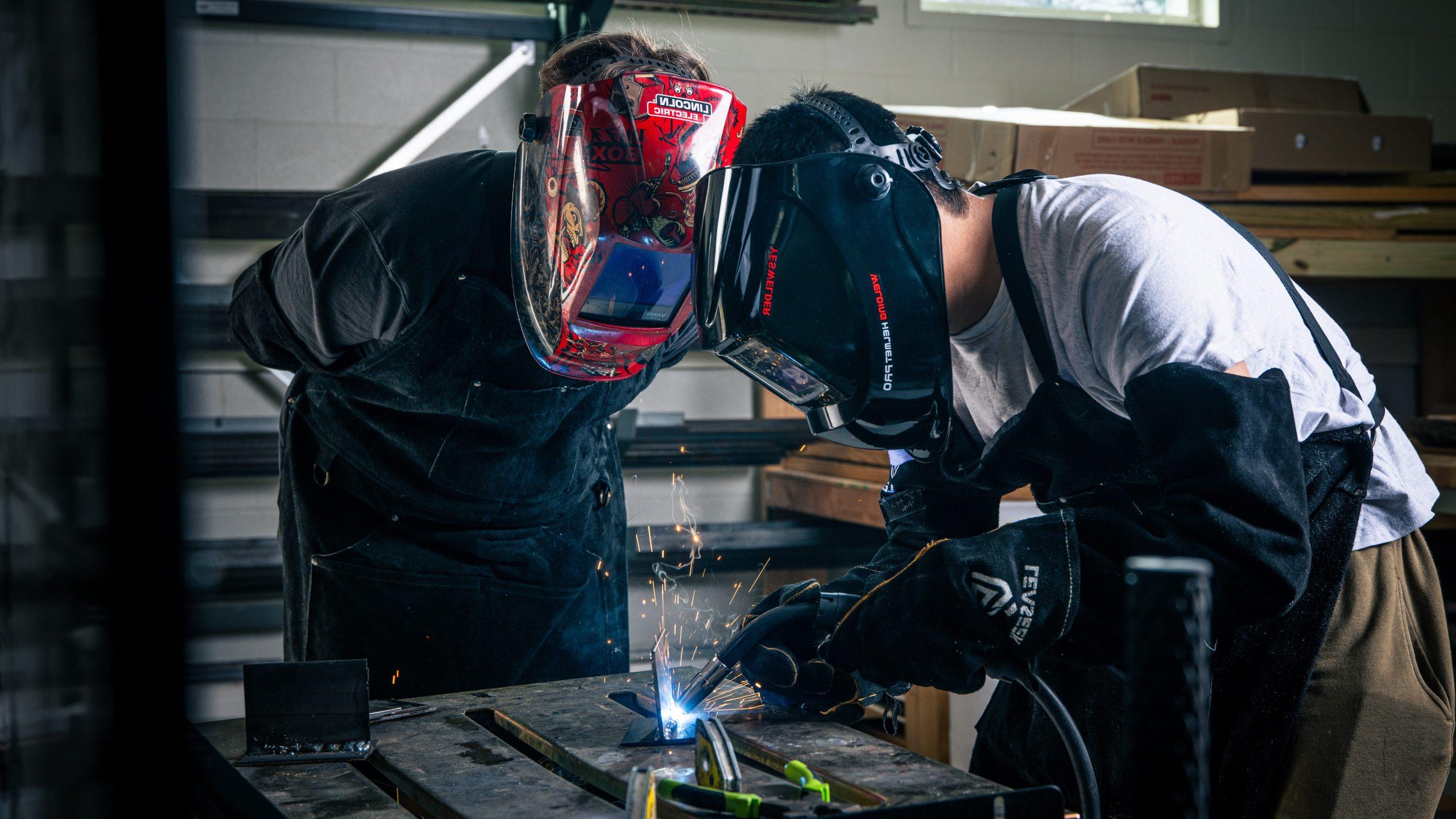 Two males working on a machine. 